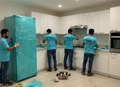 فريق نقل عفش يقوم بتغليف محتويات المطبخ في فيلا حديثة بجدة